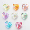 A collection of twenty acrylic heart-shaped beads in various shades of pink, yellow, and green.