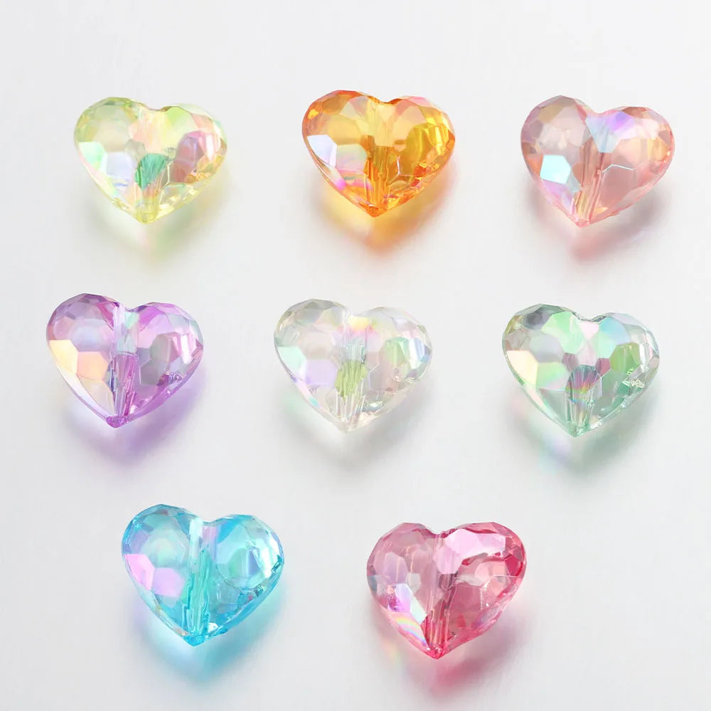 A collection of twenty acrylic heart-shaped beads in various shades of pink, yellow, and green.