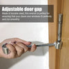 A hand holds a double-ended metal wrench used to adjust the gap between a door and frame.