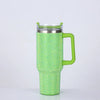 A bright lime green tumbler with a textured rhinestone pattern, featuring a metal lid and a handle.
