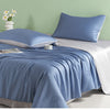 A light blue ice silk summer quilt is displayed on a bed with white linens and a matching pillow.