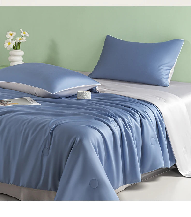A light blue ice silk summer quilt is displayed on a bed with white linens and a matching pillow.