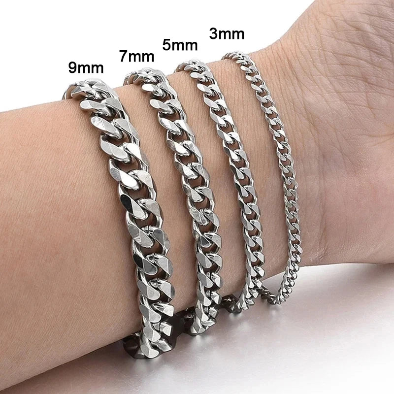 A close-up of a silver stainless steel Cuban link bracelet displayed on a wrist, showing various sizes.