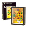 A framed yellow sunflower arrangement displayed in a black box.