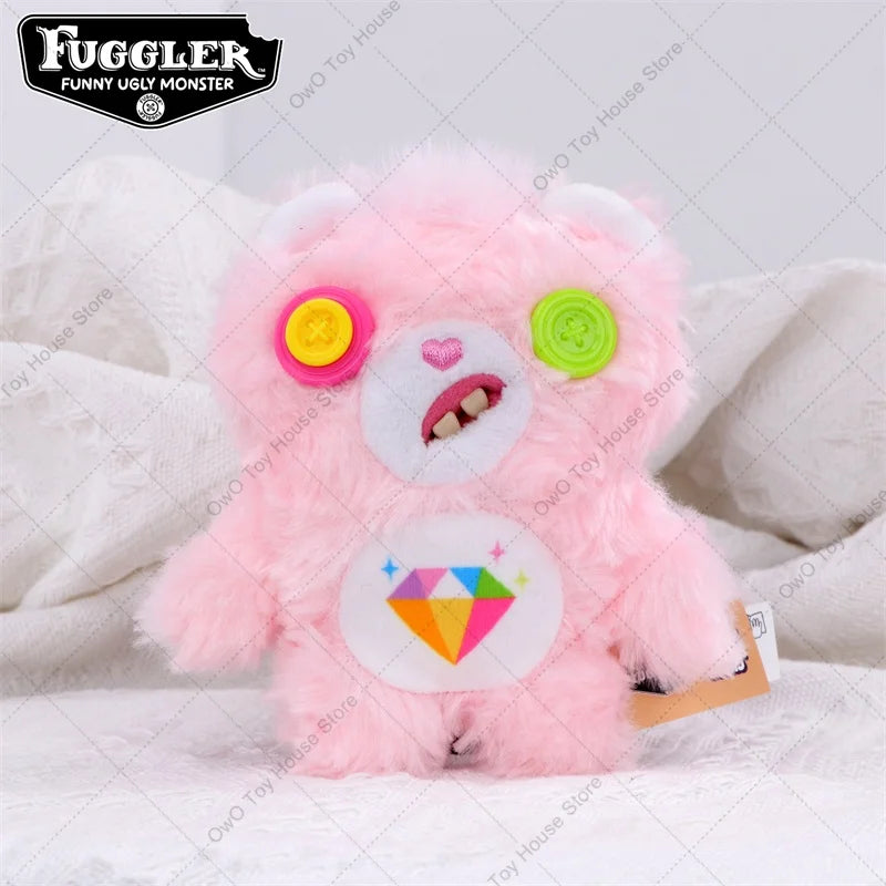 A pink Fuggler plush toy with large eyes and a diamond-shaped tag.