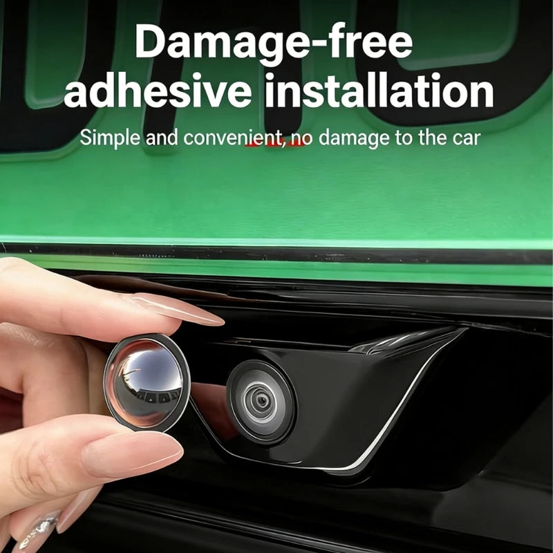 A hand installs a damage-free adhesive lens protector onto a car's rear view camera housing.