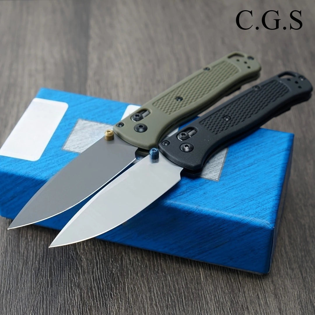 A folding knife with a drop point blade and a textured handle is displayed on a blue box.
