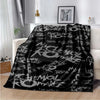 Black fleece throw blanket featuring My Chemical Romance band graphics draped on a white sofa.