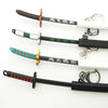 A set of three Demon Slayer mini katana replicas featuring black and green blades with decorative fittings.