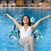 Eine junge Frau entspannt in einer aufblasbaren Wasser-Hängematte im klaren blauen Wasser.