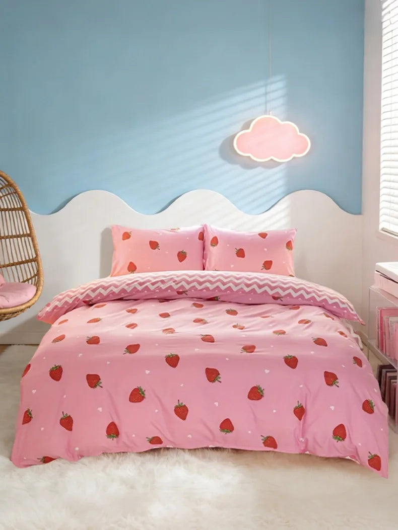 Pink strawberry print duvet cover set with matching pillowcases on a white bed against a light blue wall.