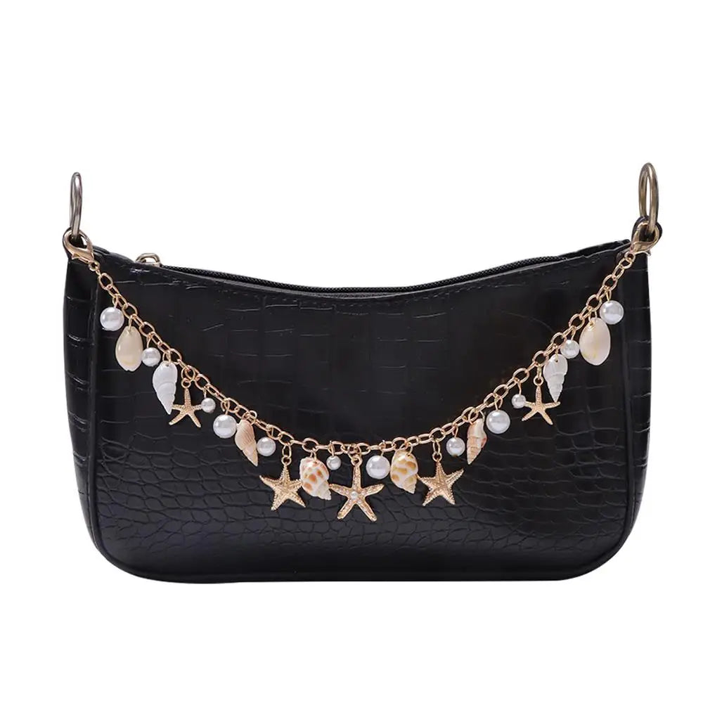 Black crocodile leather shoulder bag with a gold chain featuring starfish and pearl charms