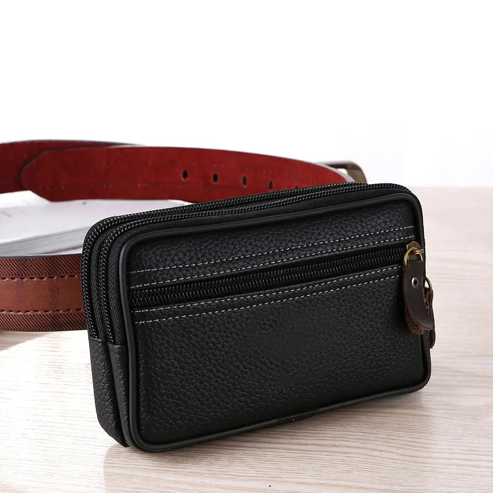 Black PU leather multi-function waist bag with a zipper and brown leather strap resting on a wooden surface.