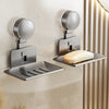 A silver wall-mounted soap dish with a drain and suction cup holder is installed on a beige wall.