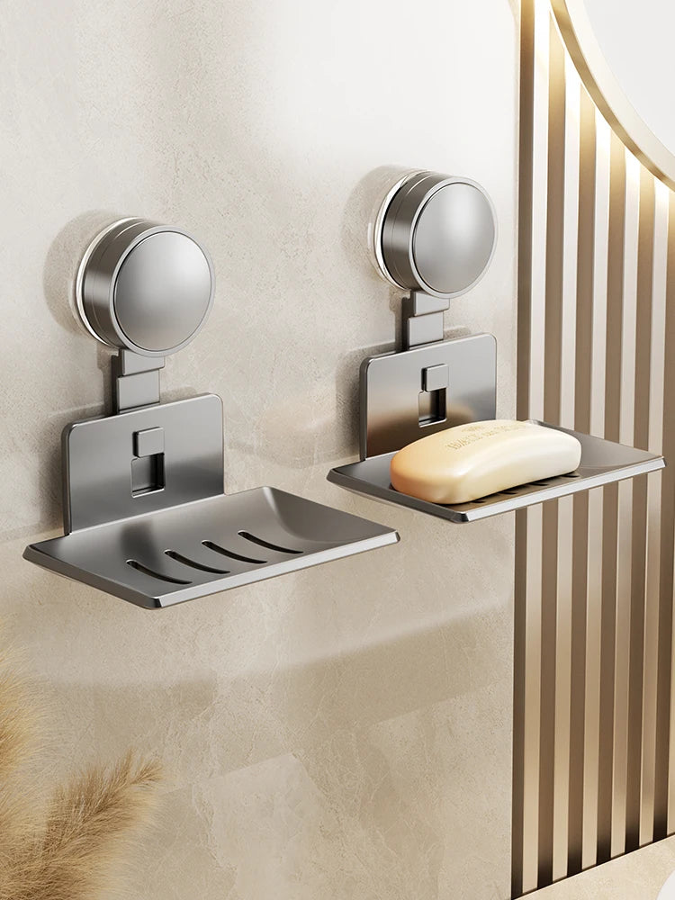 A silver wall-mounted soap dish with a drain and suction cup holder is installed on a beige wall.
