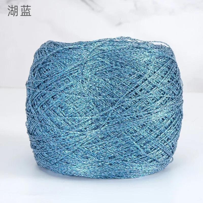 A ball of metallic blue silk crochet yarn with a shimmering texture for knitting and macrame.