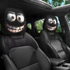 A pair of horror-themed car headrest covers featuring creepy face designs installed in a vehicle seat.