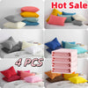 A set of four solid color microfiber pillowcases in pink, yellow, blue, and gray are displayed on a bed.