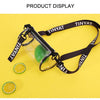 A clear crossbody bag with a green item inside and a black adjustable strap displayed on a yellow background.