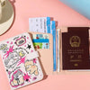 A pink and beige leather passport holder featuring a cartoon cat design and multiple passport cards.