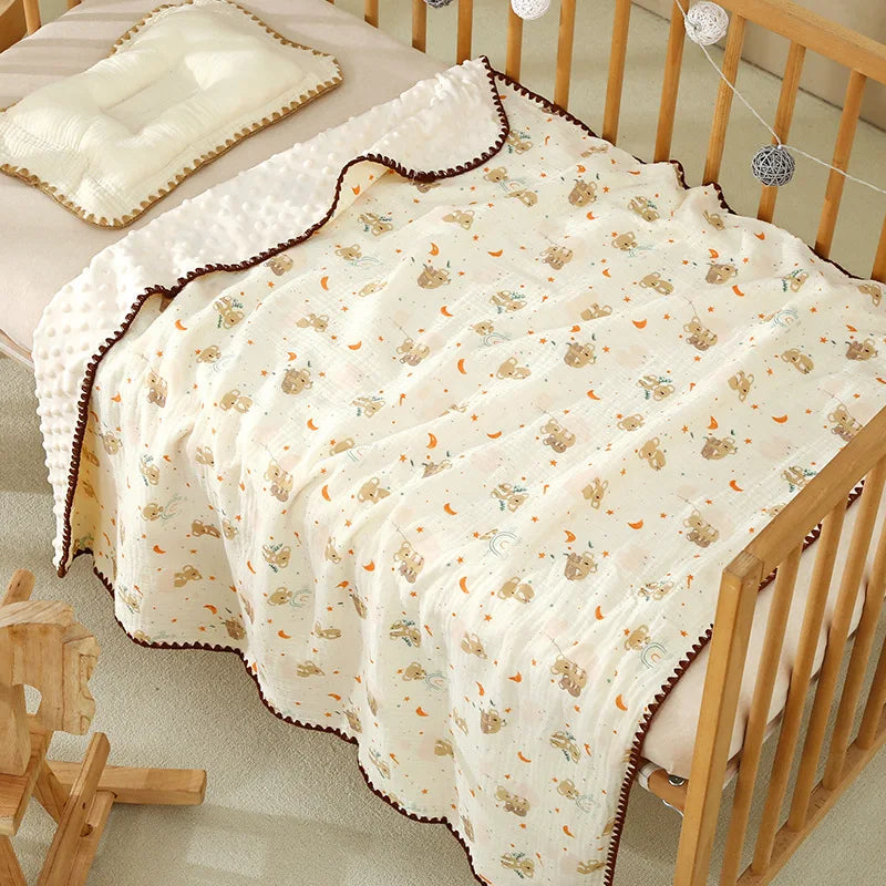 A white cotton gauze baby swaddle blanket with a bear print, draped over a wooden crib.