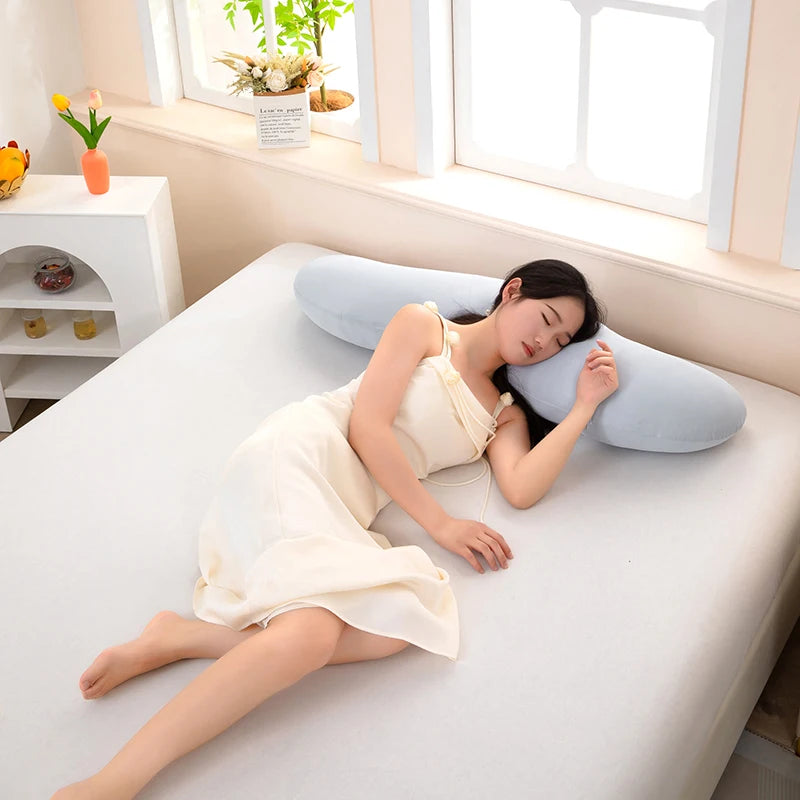 Una mujer se recuesta cómodamente en una almohada lateral con curva de ola ergonómica.