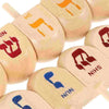 A close-up of several wooden spinning tops with engraved letters and symbols for Hanukkah and kids' play.
