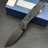 A black CPM-20CV folding pocket knife with a drop point blade resting on a blue box.