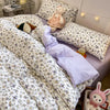 Pink floral bedding set featuring a duvet cover and pillowcases with a white and green patterned fabric.