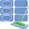 A set of three blue reusable mop pads with white borders and a green handle for cleaning.