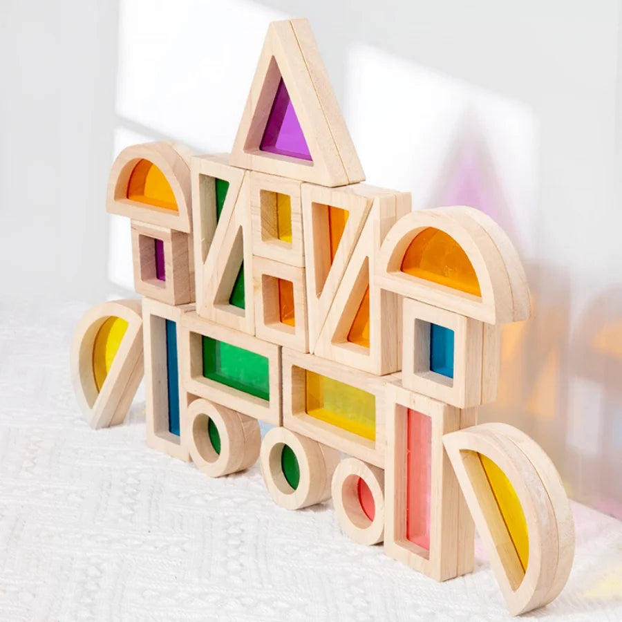A wooden building block structure shaped like a rainbow, featuring various colored acrylic blocks.
