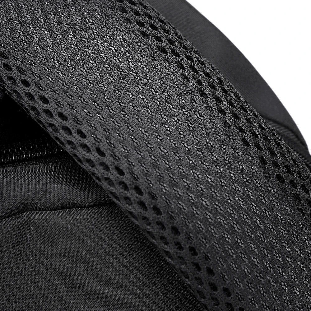Close-up of a black canvas backpack featuring a mesh fabric detail.