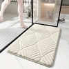 A beige plush velvet bathroom mat with a textured pattern is shown on a white marble floor.