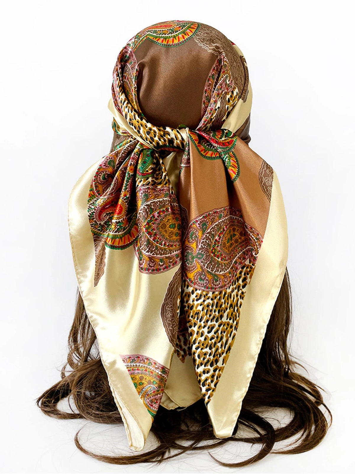 A square scarf featuring a leopard print and paisley pattern in shades of brown, gold, and green silk.