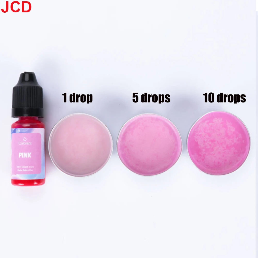 A set of pink liquid candle dye in dropper bottles showing 1, 5, and 10 drops on a pink surface.