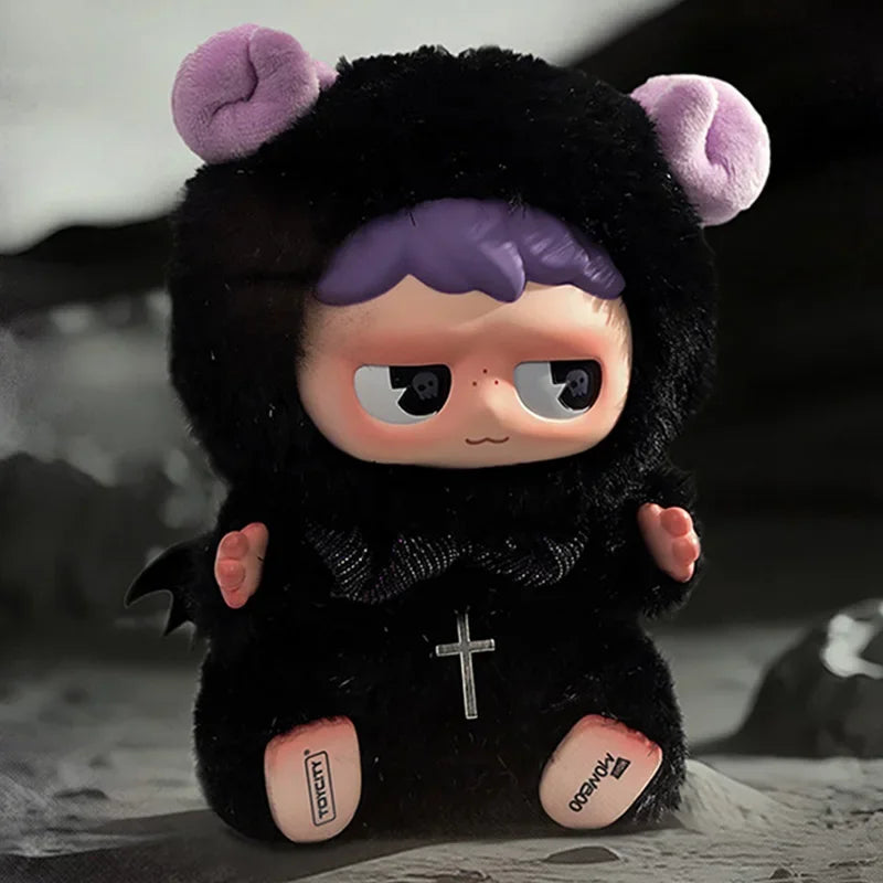 A black monster plush toy with purple ears and a small cross detail.