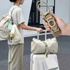 A hand is holding an adjustable luggage strap with a quick-release buckle, demonstrating its use for carrying a backpack.