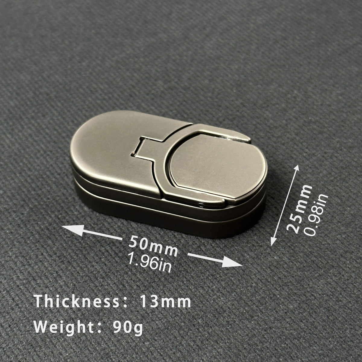 A silver metal fidget slider with a rectangular shape is shown on a dark surface.