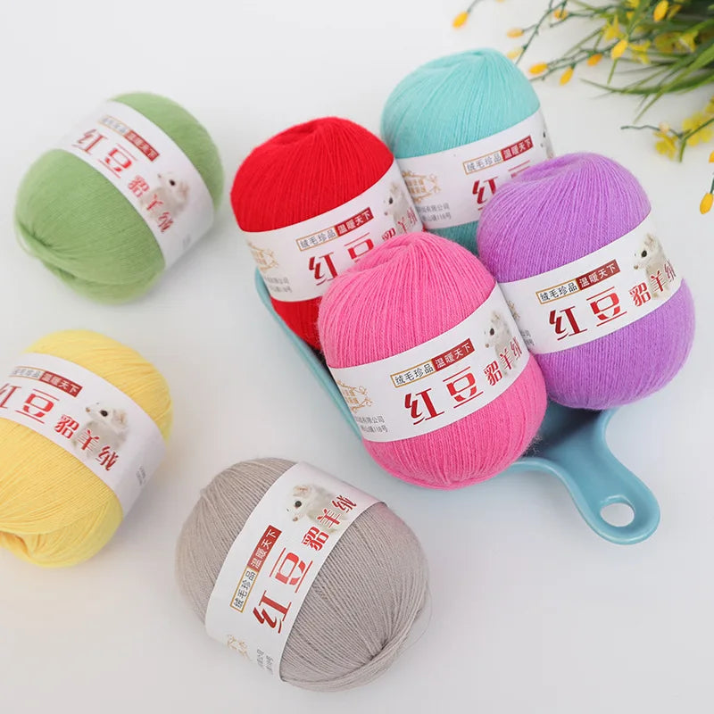 A collection of brightly colored fine yarn skeins in various shades including green, red, purple, yellow, and gray for knitti