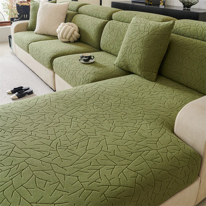 A section of a moss green jacquard fleece sofa cover with an embossed leaf pattern and anti-slip backing.