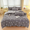 Gray bedding set featuring a duvet cover, fitted sheet, and pillows with white triangle pattern.