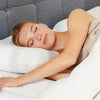 A woman is sleeping comfortably on a white memory foam pillow in a modern bedroom setting.