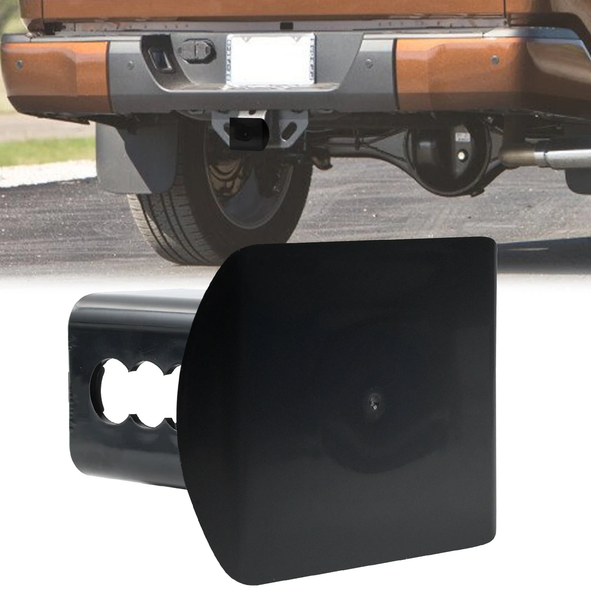 Black 2-inch trailer hitch receiver plug cover installed on a vehicle's rear bumper.