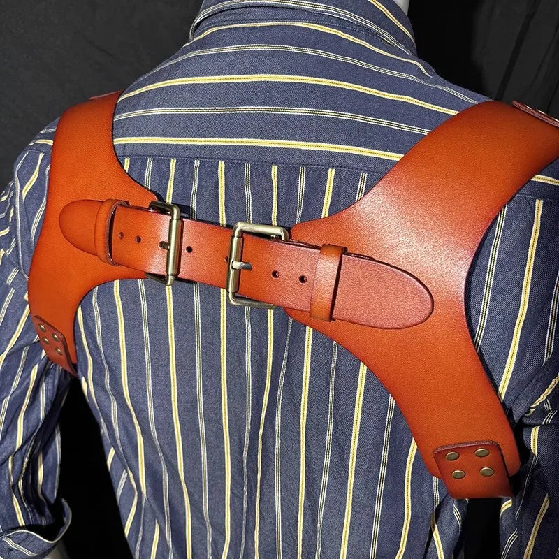 A pair of brown leather double shoulder suspenders worn over a blue striped shirt.