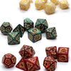 A collection of dragon-embellished polyhedral dice in gold and green colors.