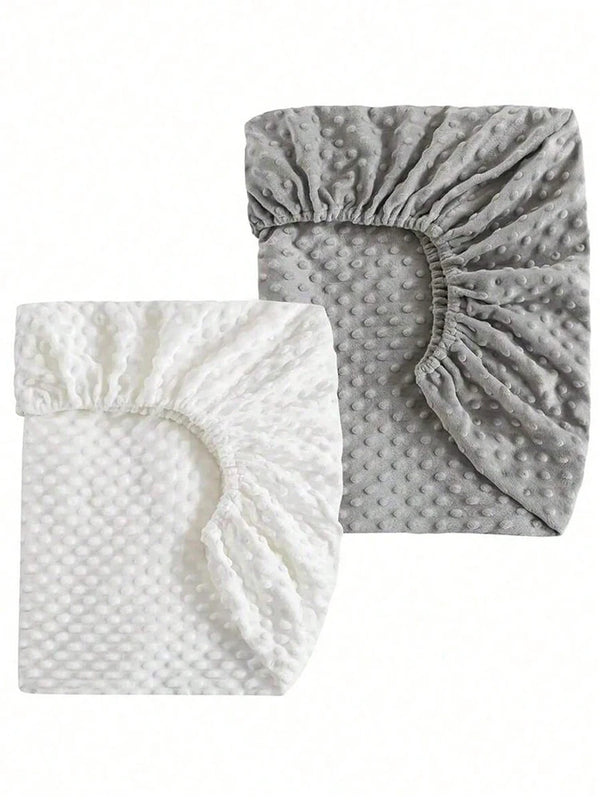 Un ensemble de housses de matelas douces et moelleuses pour bébé et enfant, une blanche et une grise.