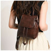 Mini sac à dos en cuir marron avec cordon, porté par une personne aux longs cheveux noirs et un haut de couleur claire.