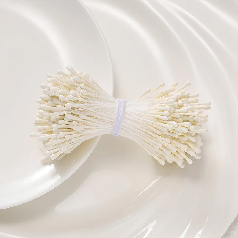 A bundle of 400 pearl flower stamens for DIY crafts and wedding decor placed on a white plate.