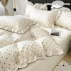 A set of three white bedding pieces featuring a modern black dot print on a duvet cover and pillow core.