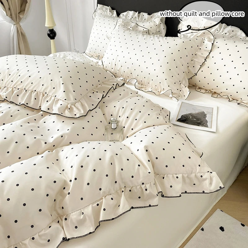 A set of three white bedding pieces featuring a modern black dot print on a duvet cover and pillow core.